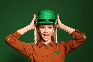 Photo of Young woman in green hat on color background. St. Patrick's Day celebration