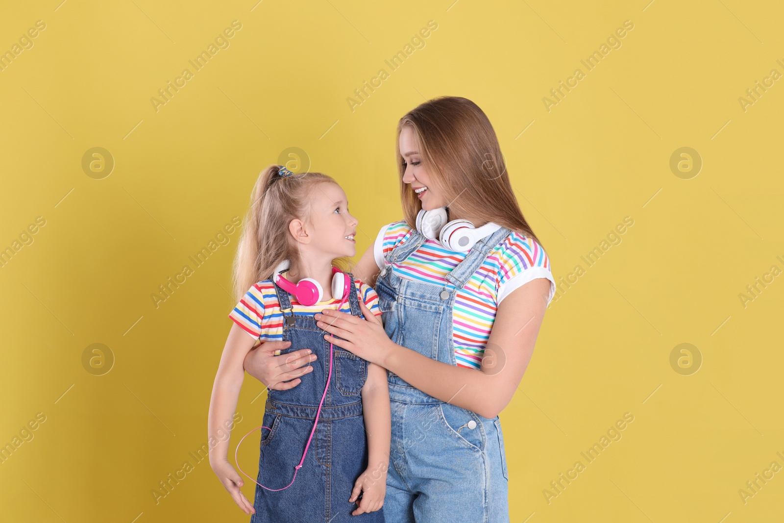 Photo of Happy mother and little daughter on yellow background