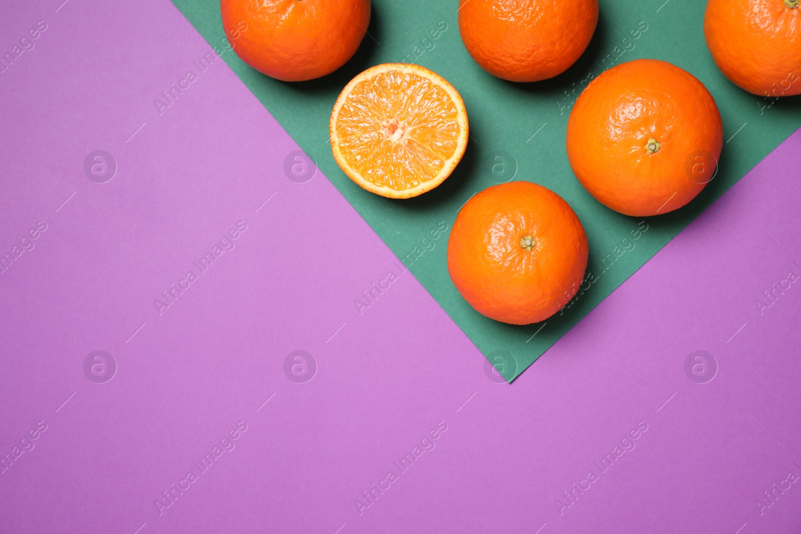 Photo of Fresh ripe tangerines on color background, flat lay. Space for text