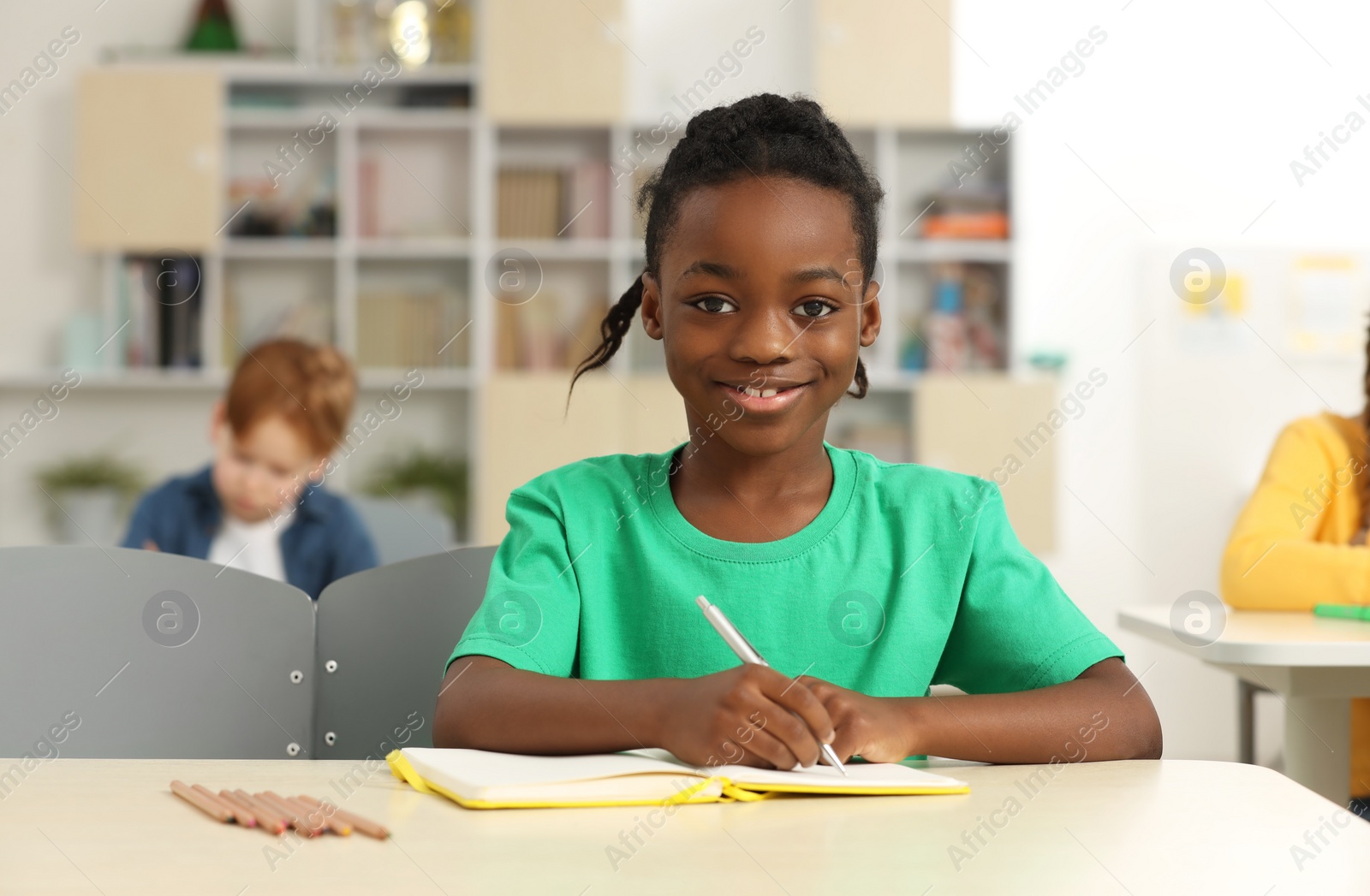 Photo of Portrait of smiling little boy studying in classroom at school