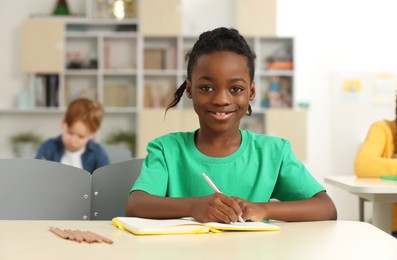 Photo of Portrait of smiling little boy studying in classroom at school