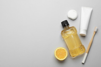 Photo of Mouthwash and other oral hygiene products on light grey background, flat lay. Space for text