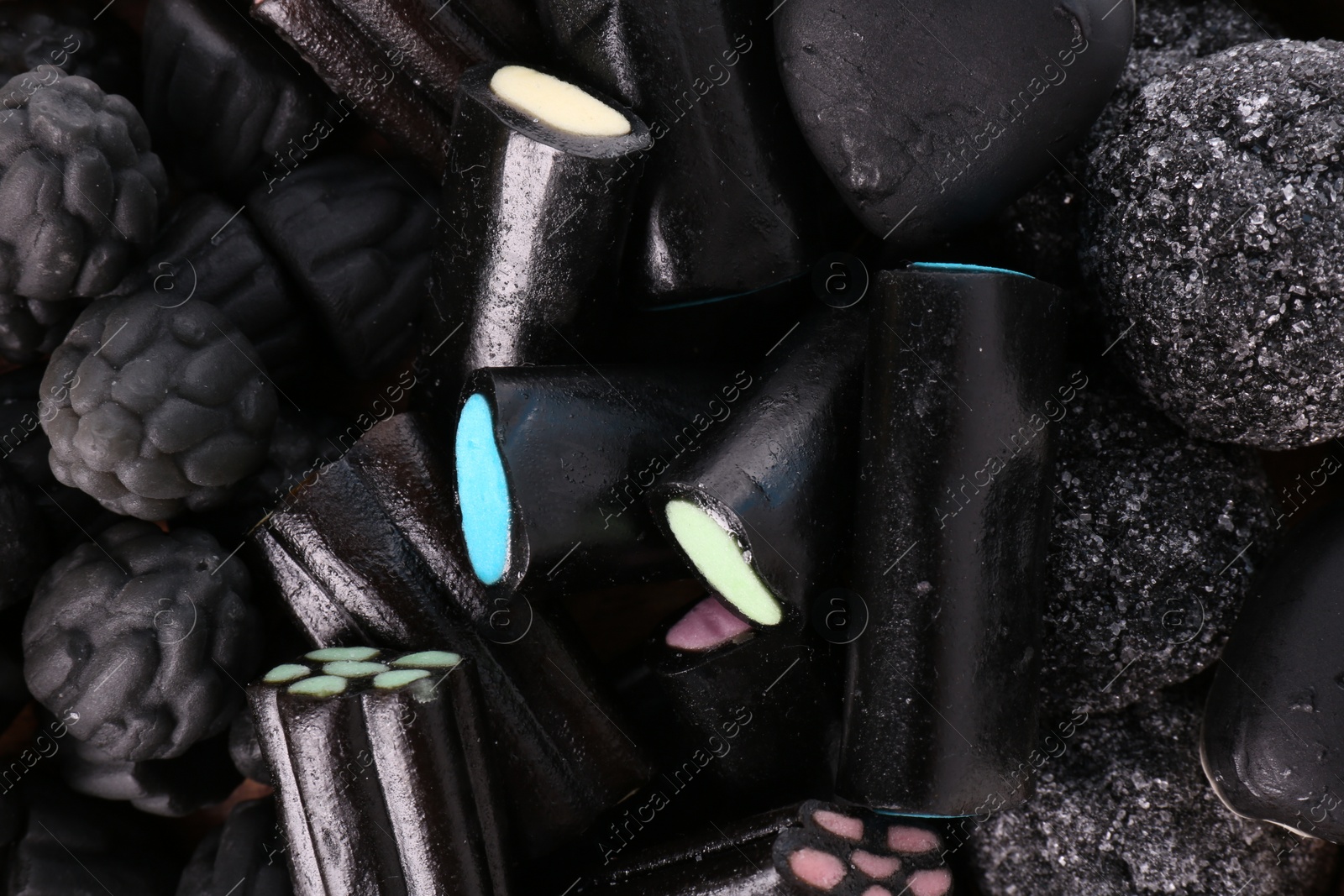 Photo of Many tasty liquorice candies as background, top view