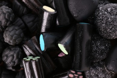 Many tasty liquorice candies as background, top view