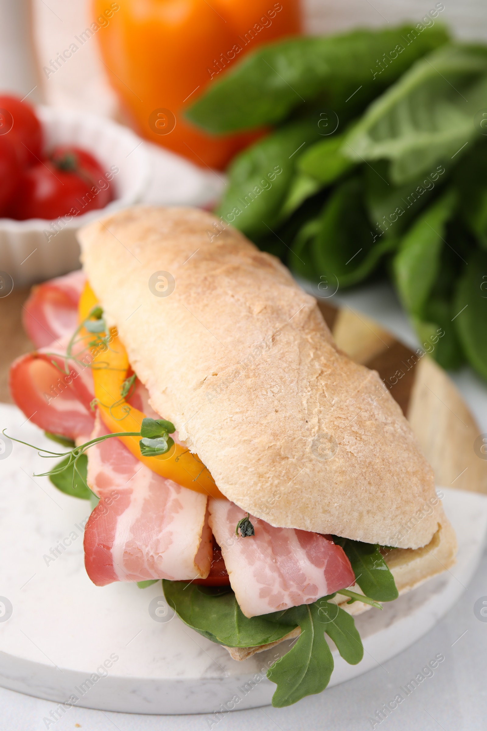 Photo of Tasty sandwich with bacon and bell pepper on white table, closeup