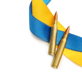 Photo of Ribbons in colors of national Ukrainian flag and bullets on white background, flat lay. Space for text