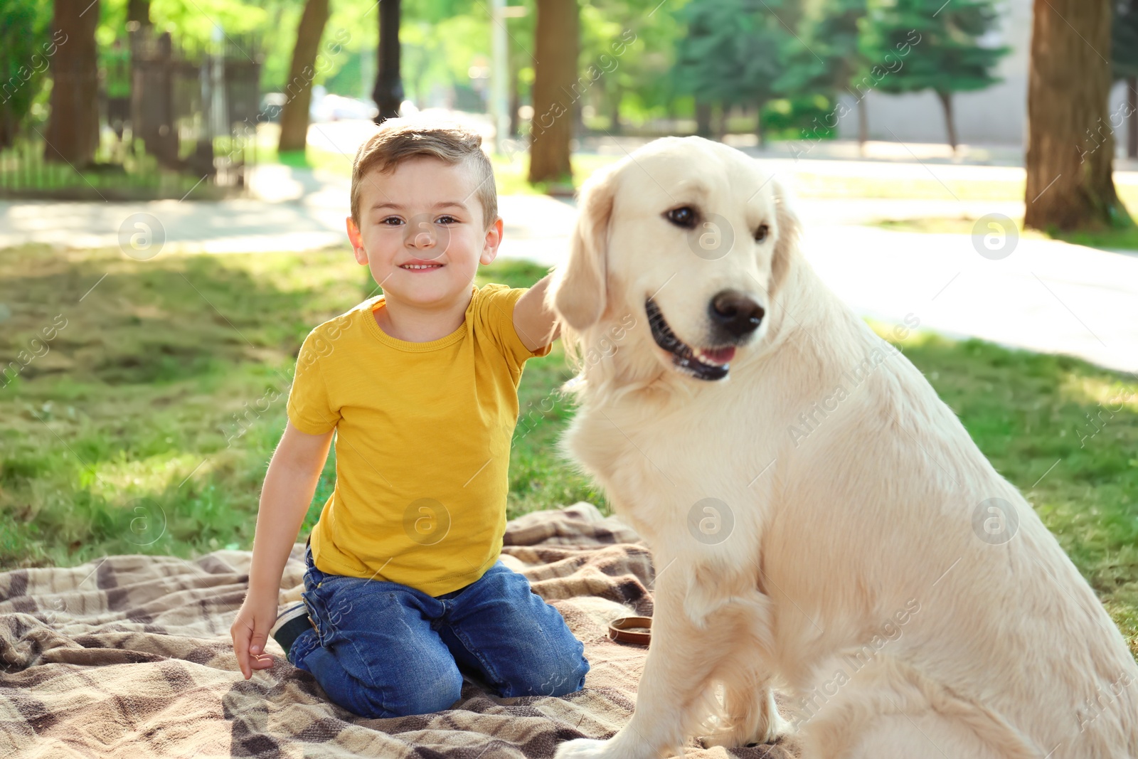 Photo of Cute little child with his pet in green park