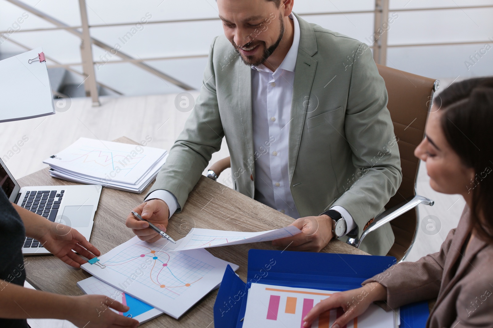 Photo of Office employees working with documents at table indoors