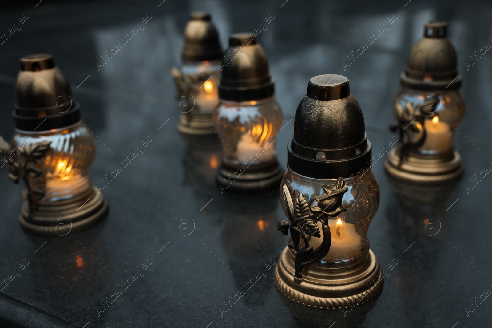 Photo of Grave lights on granite surface at cemetery