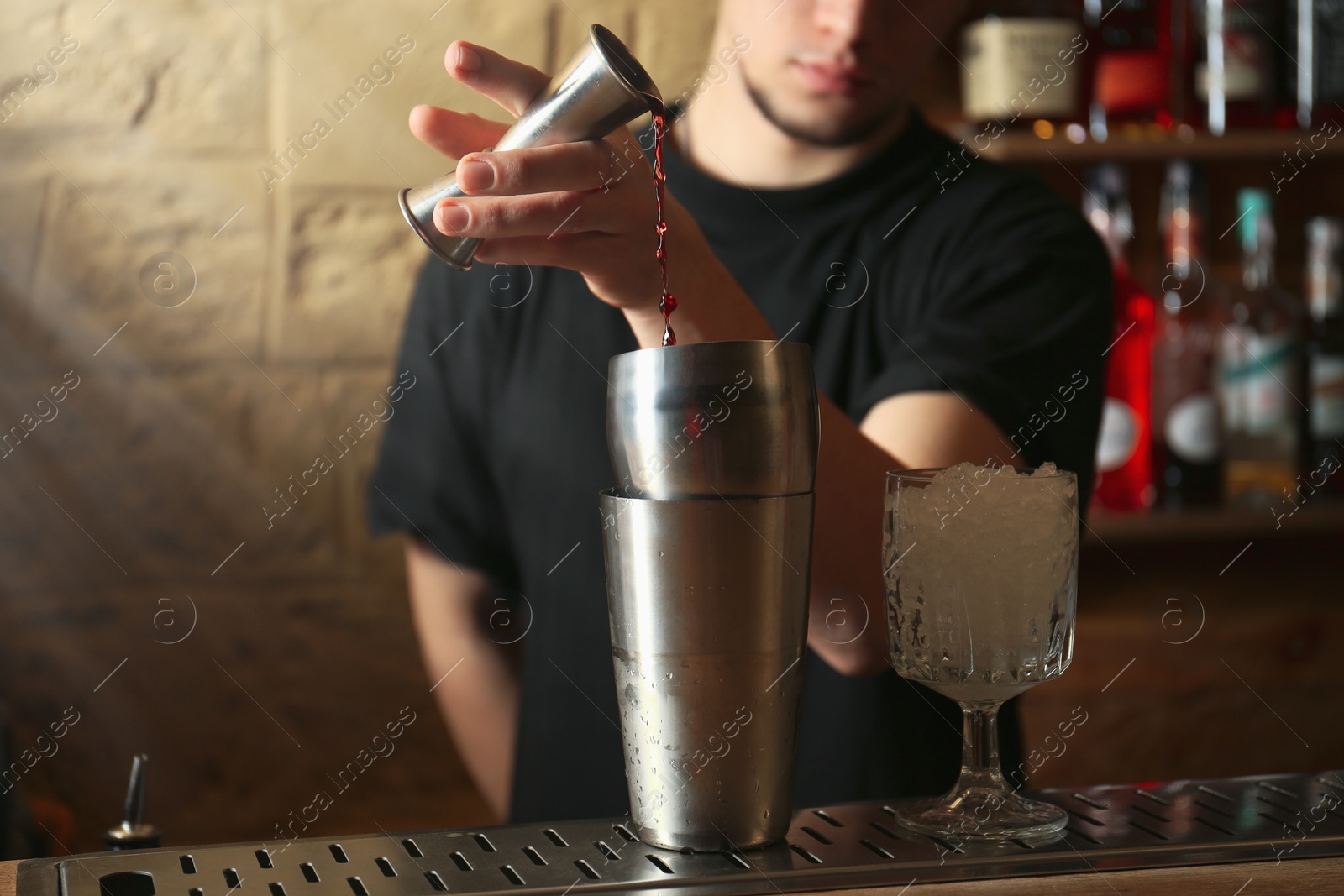 Photo of Bartender preparing fresh alcoholic cocktail at bar counter, closeup