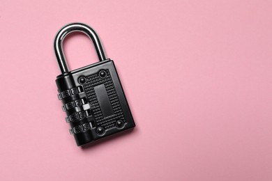 Photo of Steel combination padlock on pink background, top view. Space for text