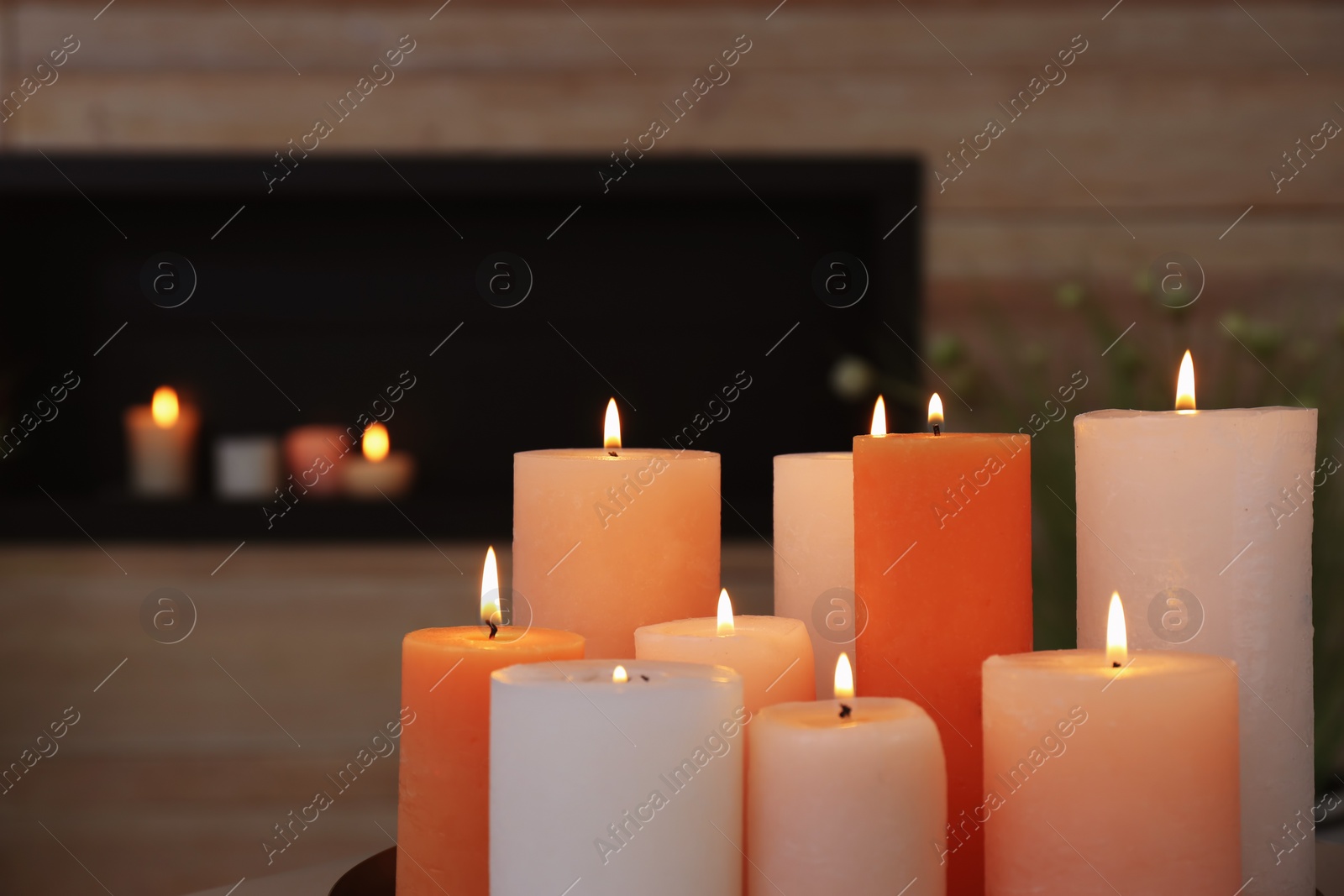 Photo of Burning aromatic candles in living room, closeup view