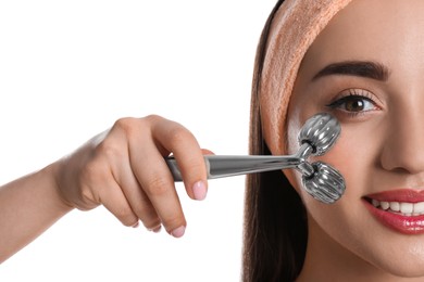 Photo of Woman using metal face roller on white background, closeup
