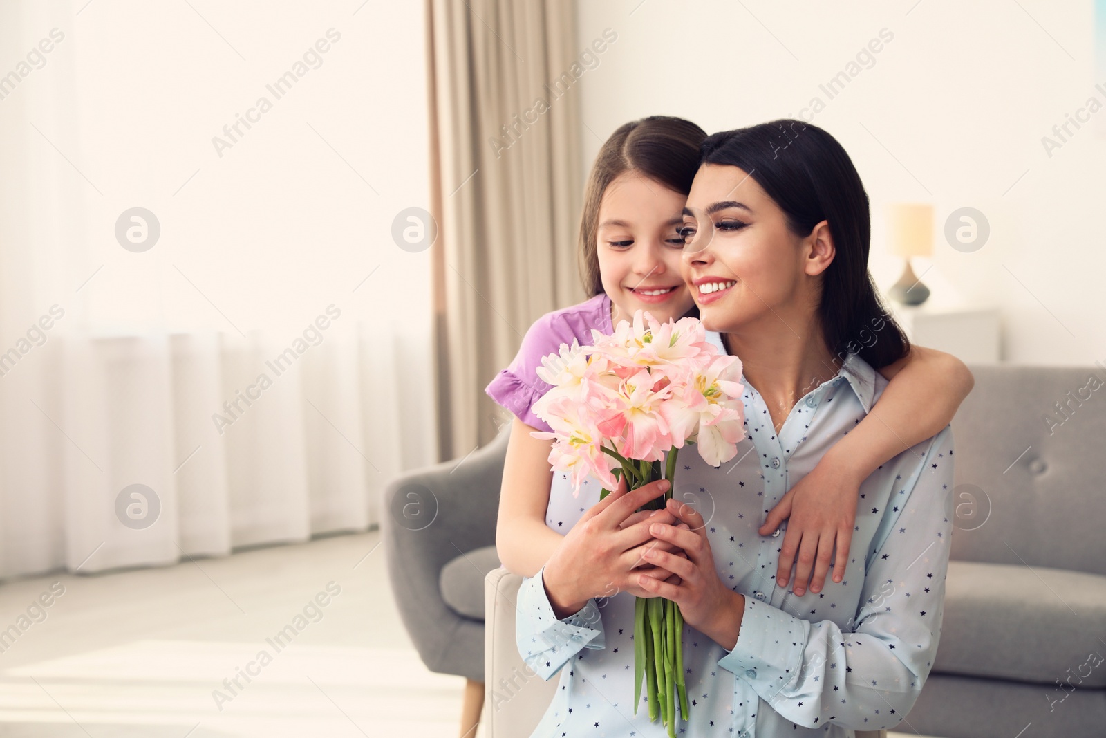 Photo of Little daughter congratulating her mom at home, space for text. Happy Mother's Day