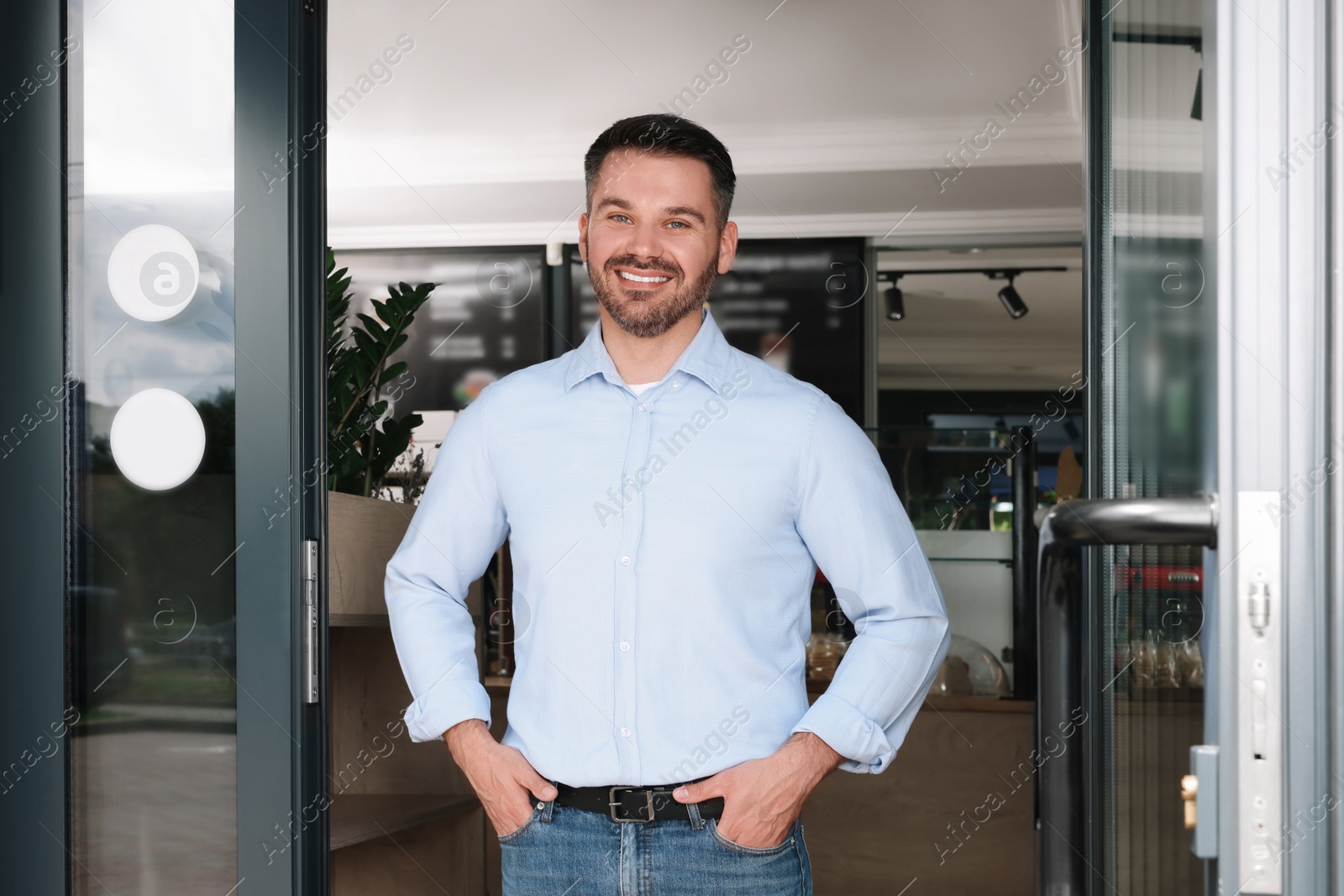 Photo of Happy business owner at door of his cafe