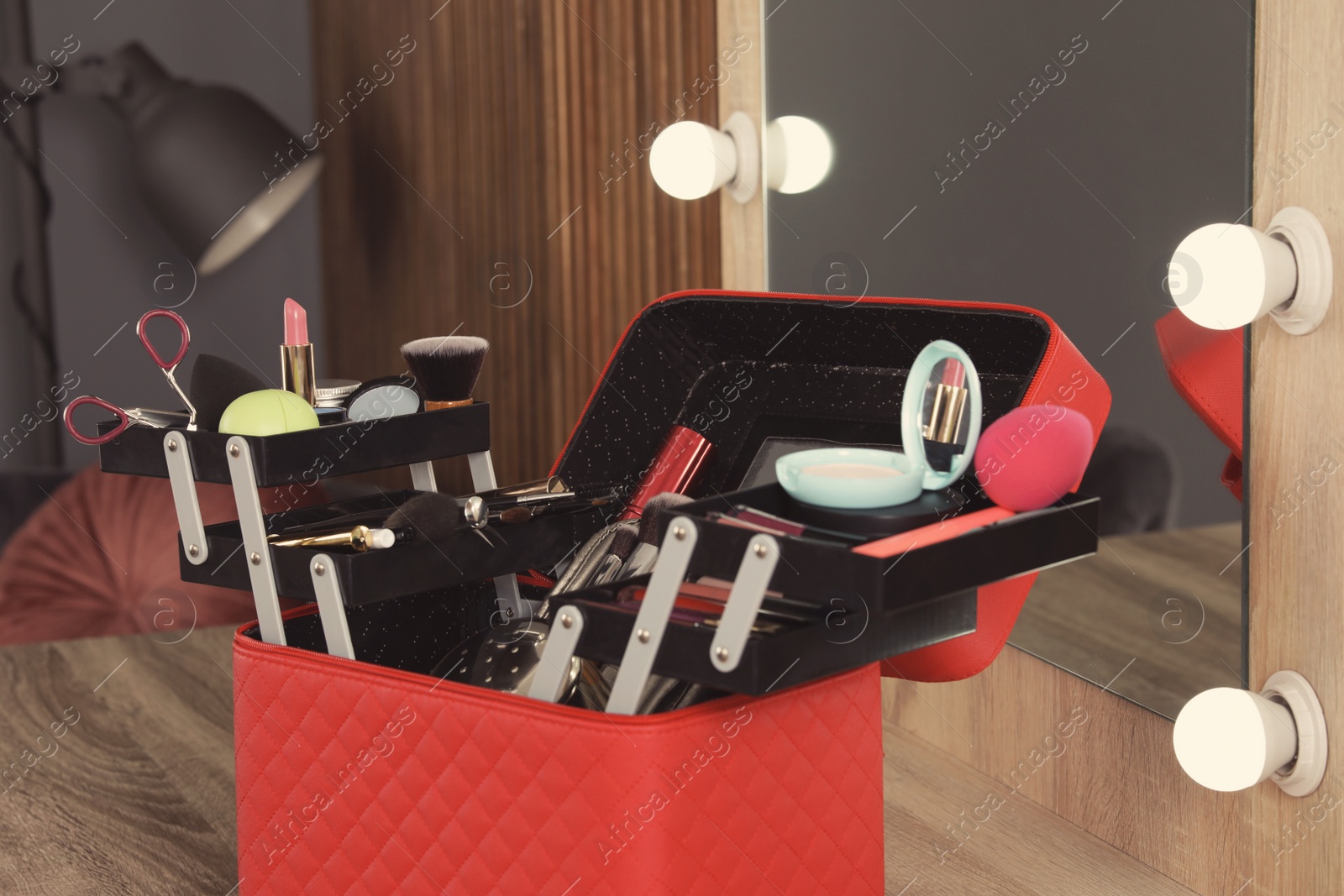 Photo of Beautician case with professional makeup products and tools on dressing table