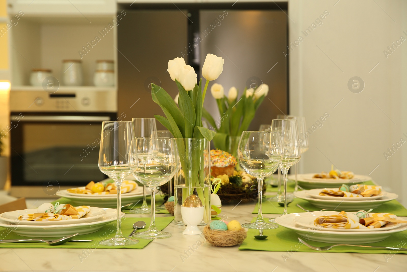 Photo of Festive Easter table setting with floral decor in kitchen