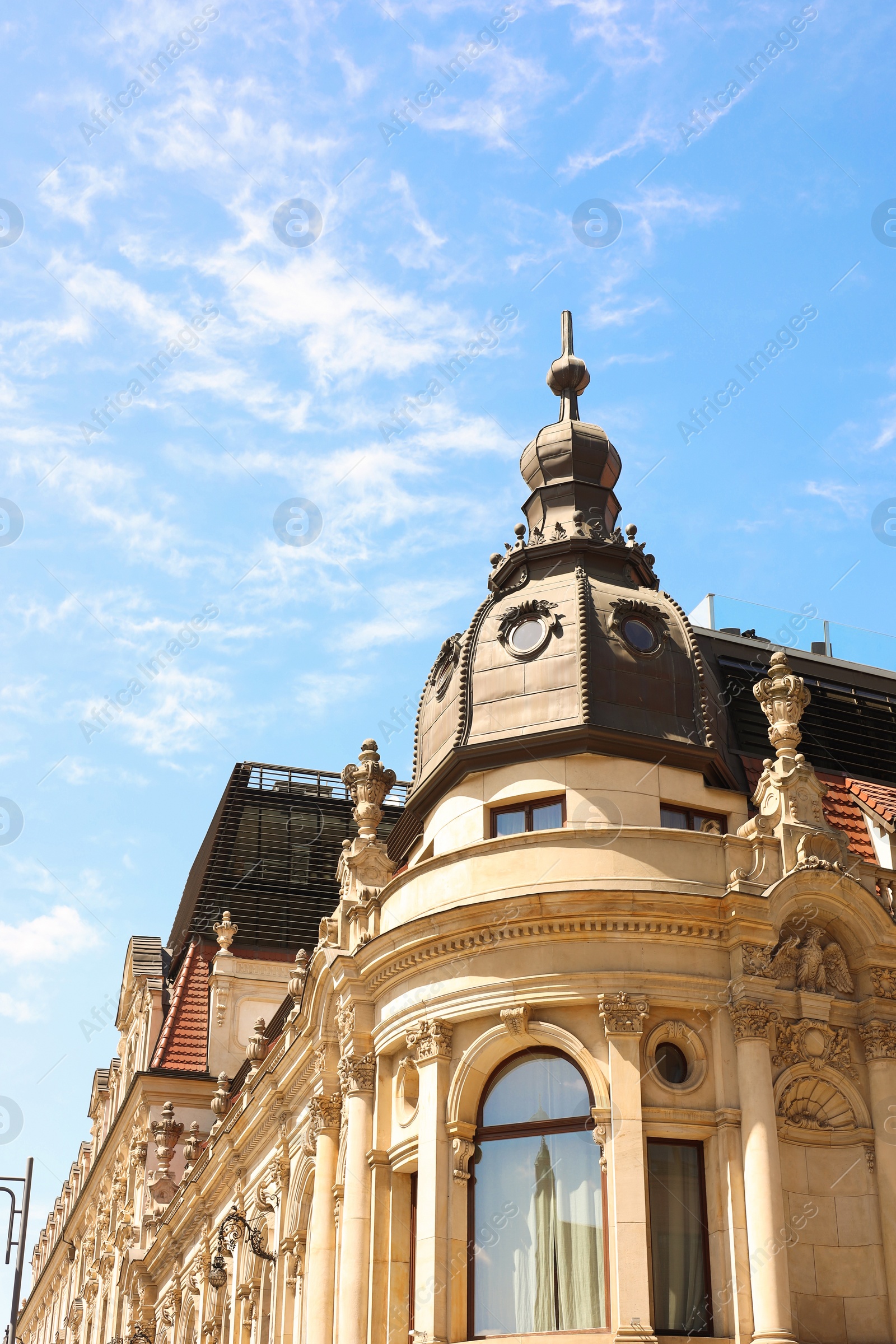 Photo of Facade of old building with sculptures against blue sky, low angle view