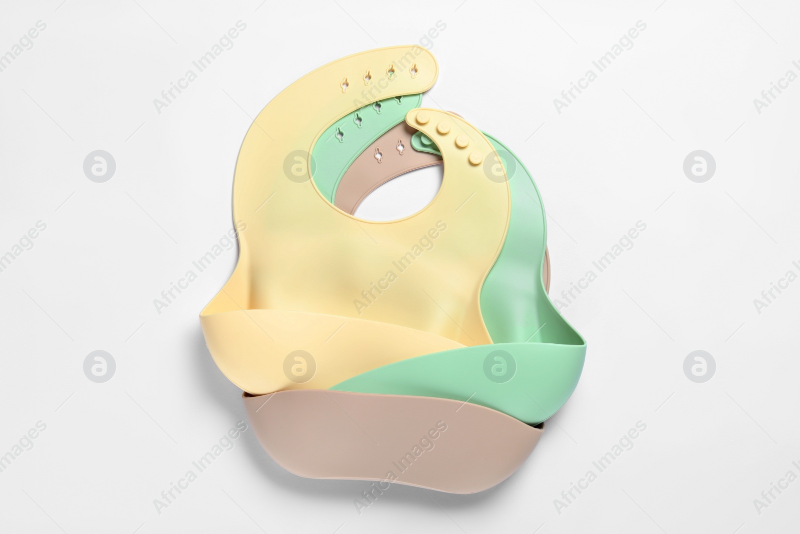 Photo of Color silicone baby bibs isolated on white, top view