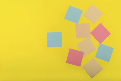 Colorful sticky notes on yellow background, flat lay. Space for text