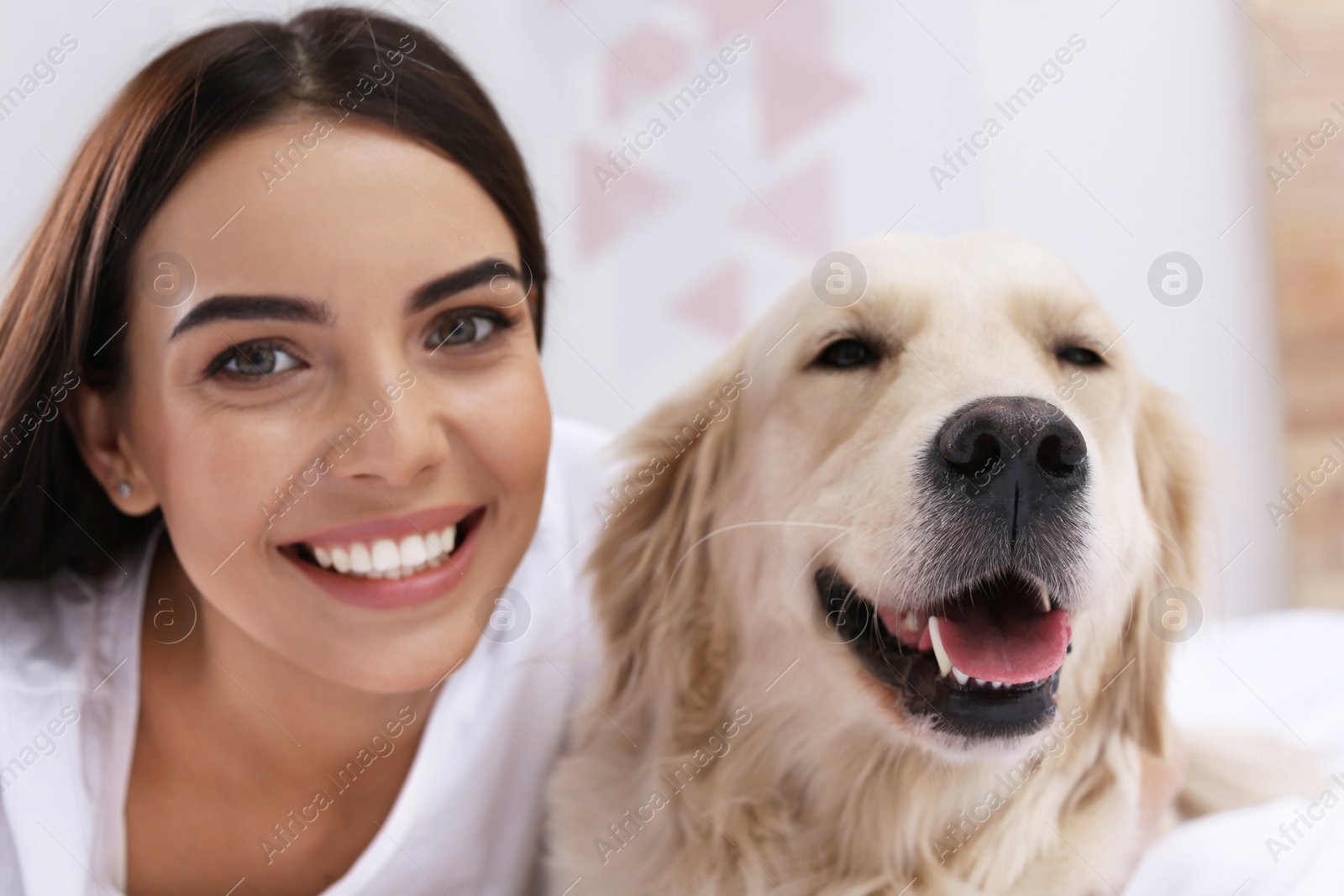 Image of Happy woman with her cute pet dog at home