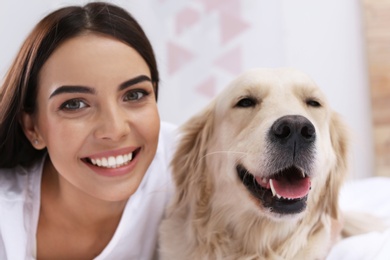 Happy woman with her cute pet dog at home