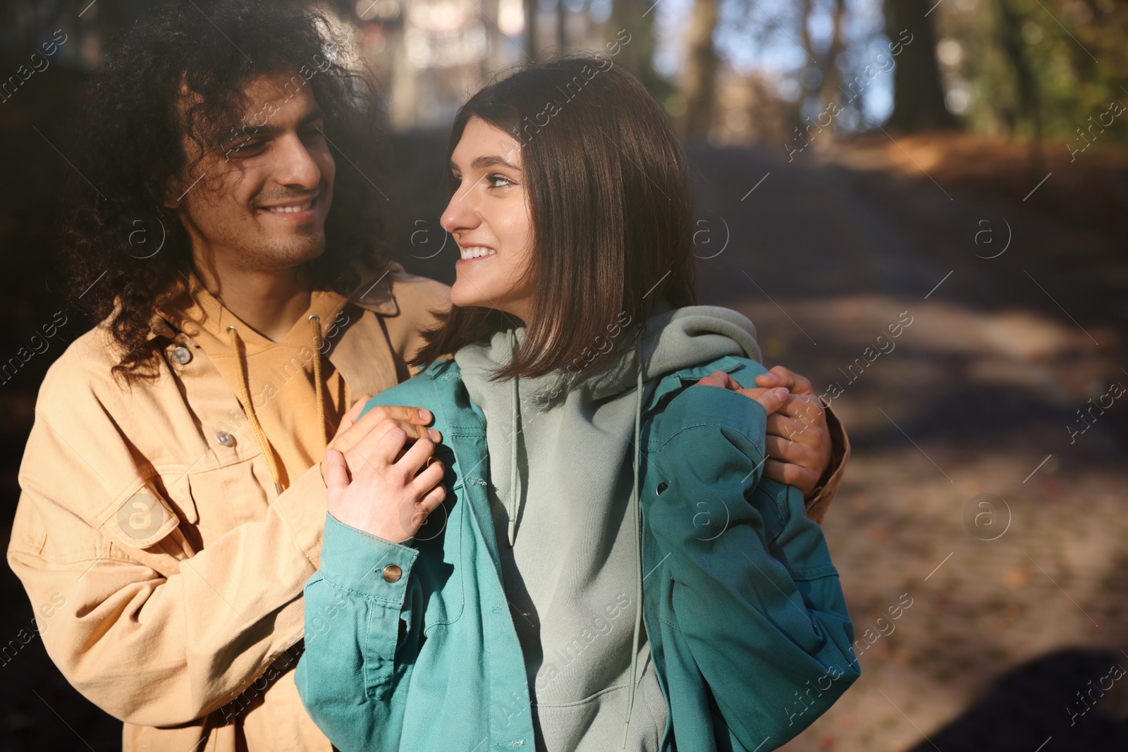 Photo of Happy young couple spending time together in autumn park, space for text. Dating agency