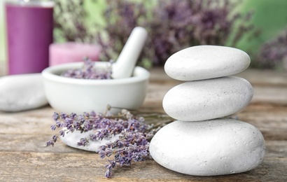 Photo of Spa stones with lavender flowers on table. Ingredient for natural cosmetic