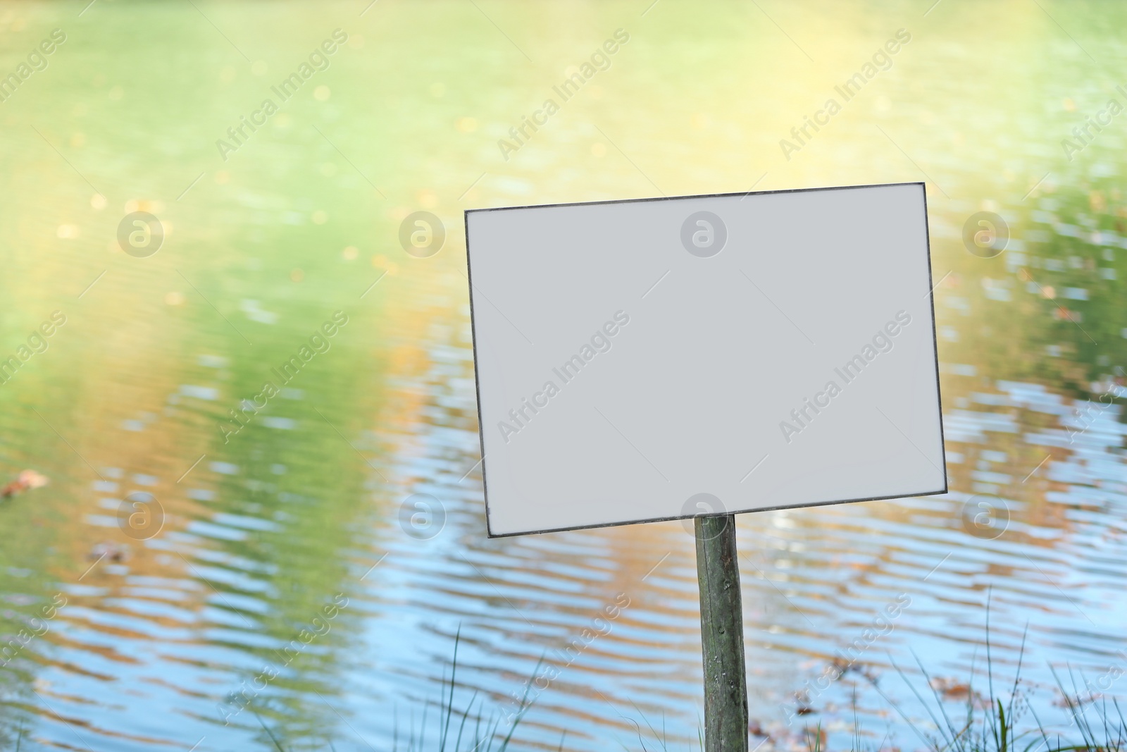 Photo of Empty sign board near pond. Space for text