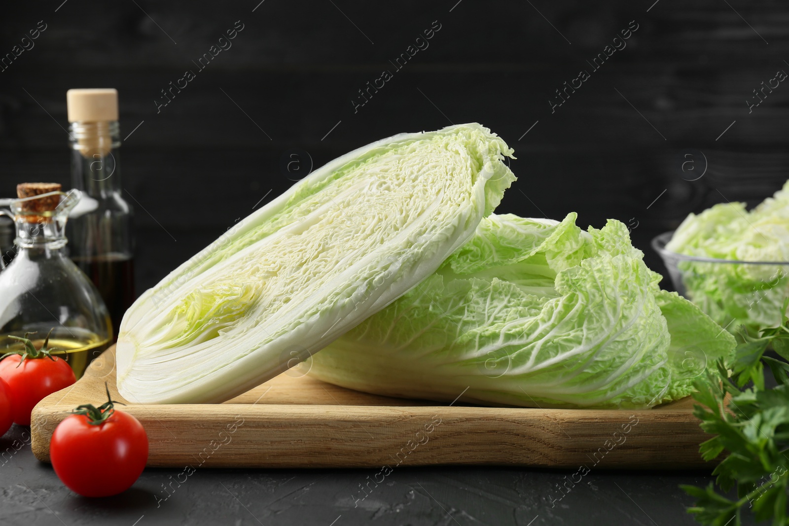 Photo of Fresh Chinese cabbages and other products on black textured table