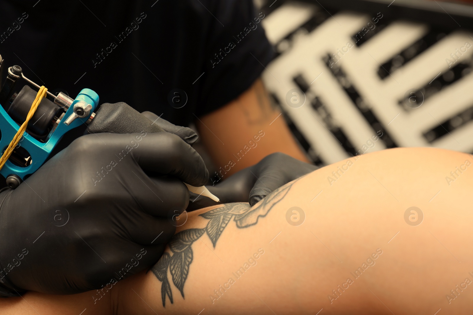 Photo of Professional artist making tattoo in salon, closeup