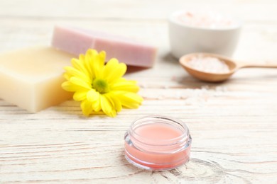 Photo of Lip balm with natural beeswax component on white wooden table, closeup