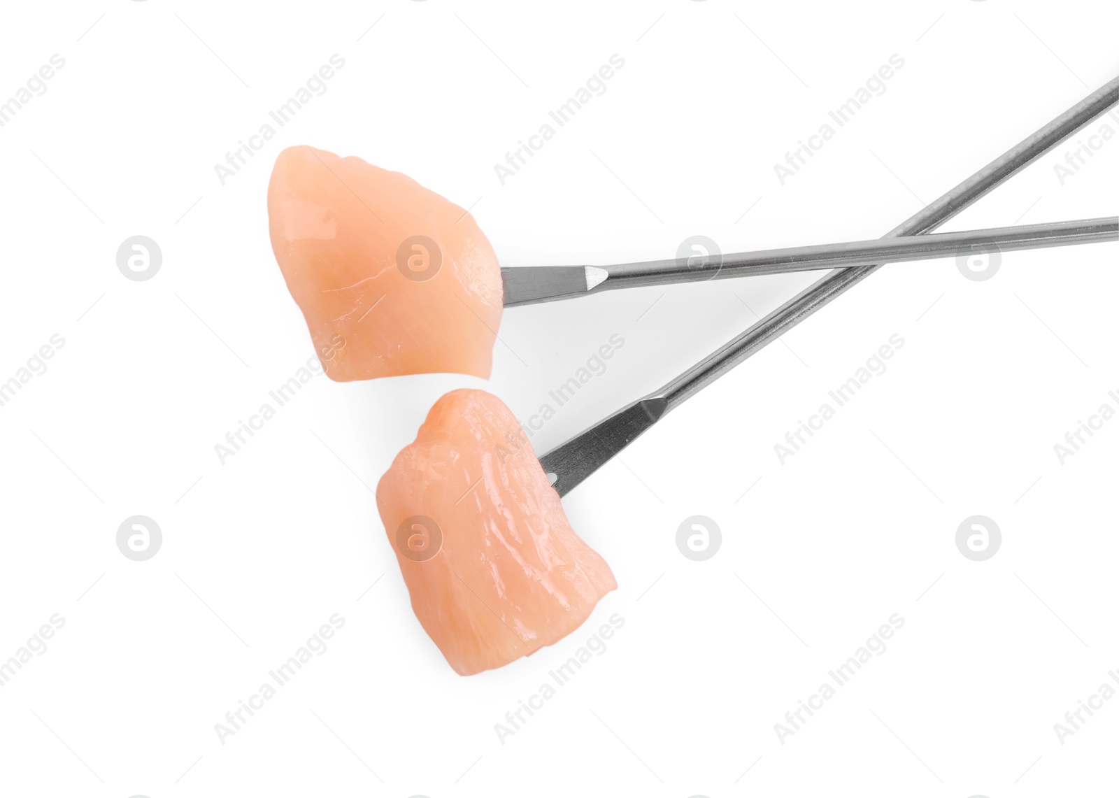 Photo of Fondue forks with pieces of raw meat isolated on white, top view