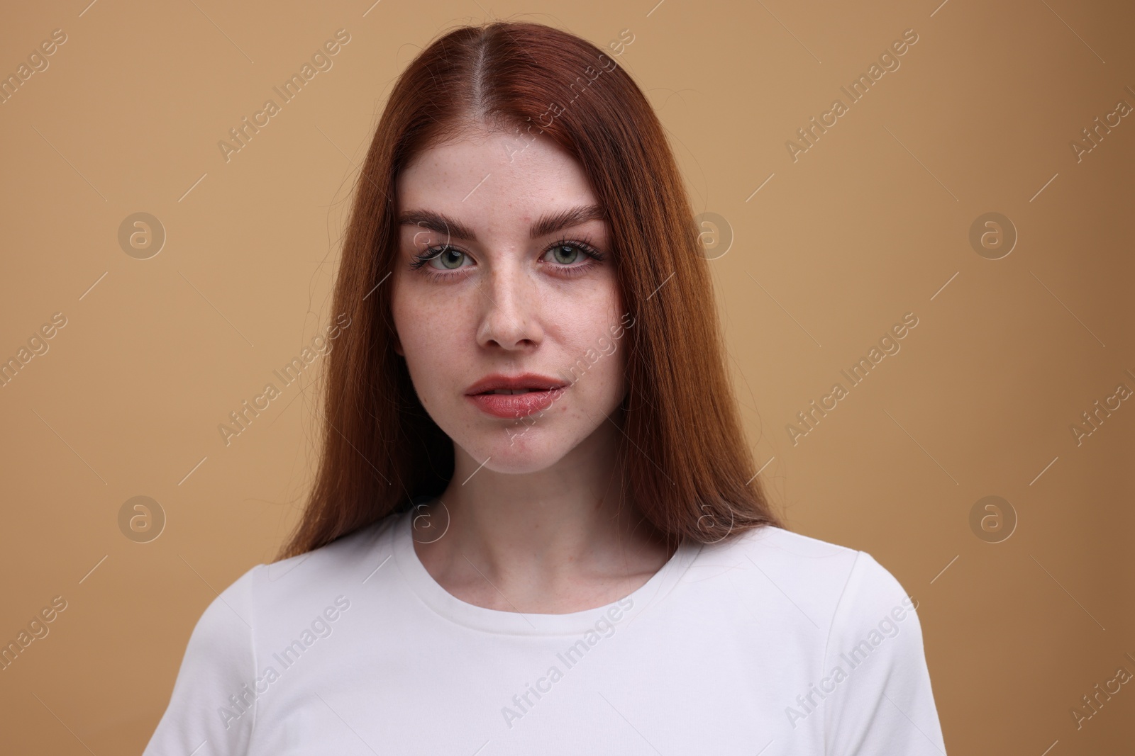 Photo of Portrait of beautiful woman with freckles on beige background