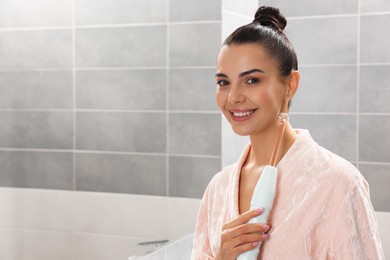 Photo of Woman using high frequency darsonval device in bathroom, space for text