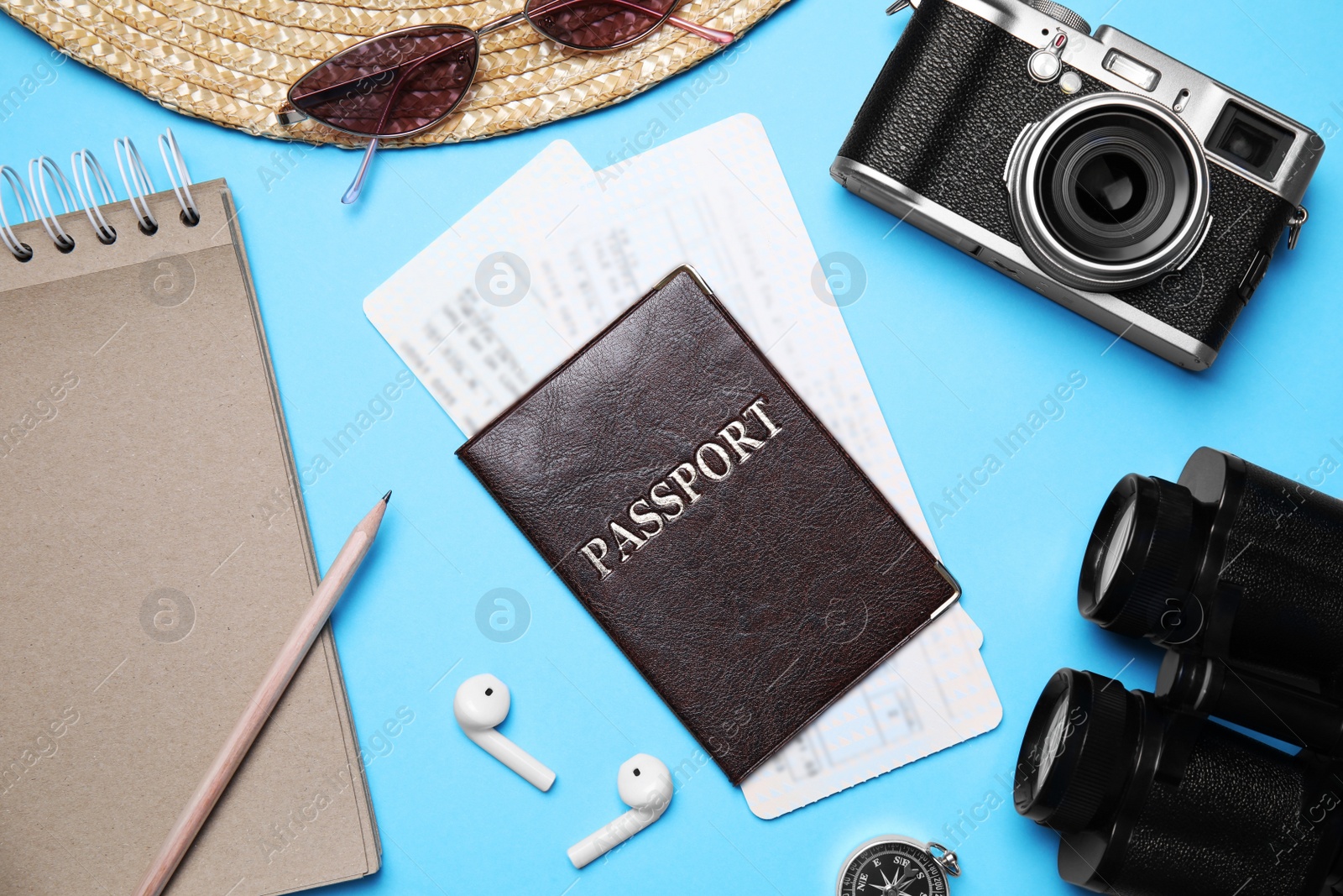 Photo of Flat lay composition with passport, tickets and holiday items on light blue background