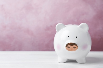 Photo of White piggy bank on table. Money saving