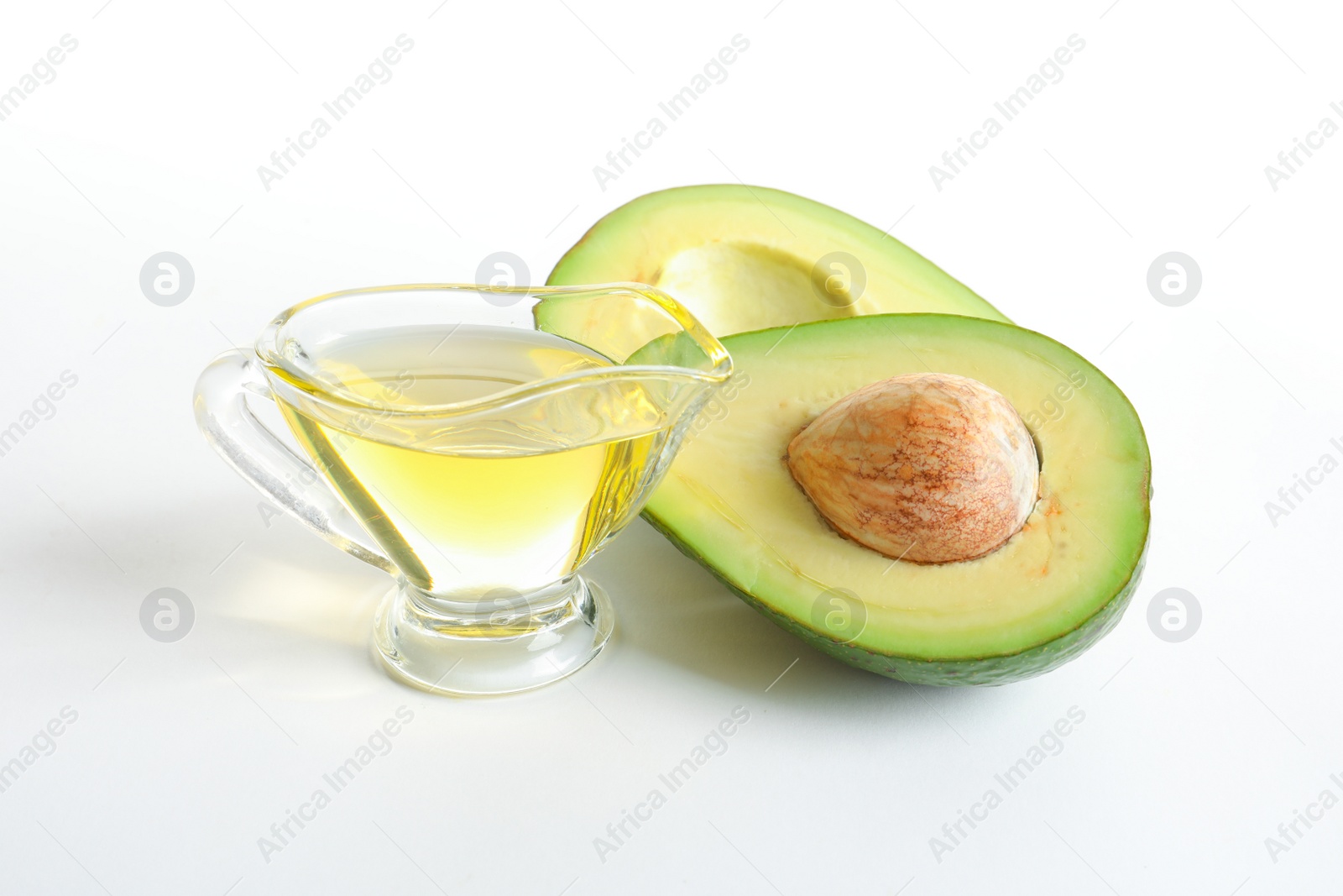 Photo of Gravy boat with oil and ripe fresh avocado on white background