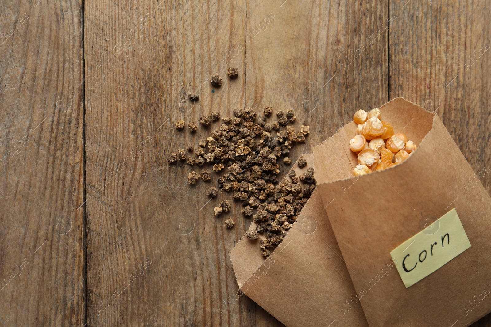 Photo of Different vegetable seeds on wooden table, flat lay