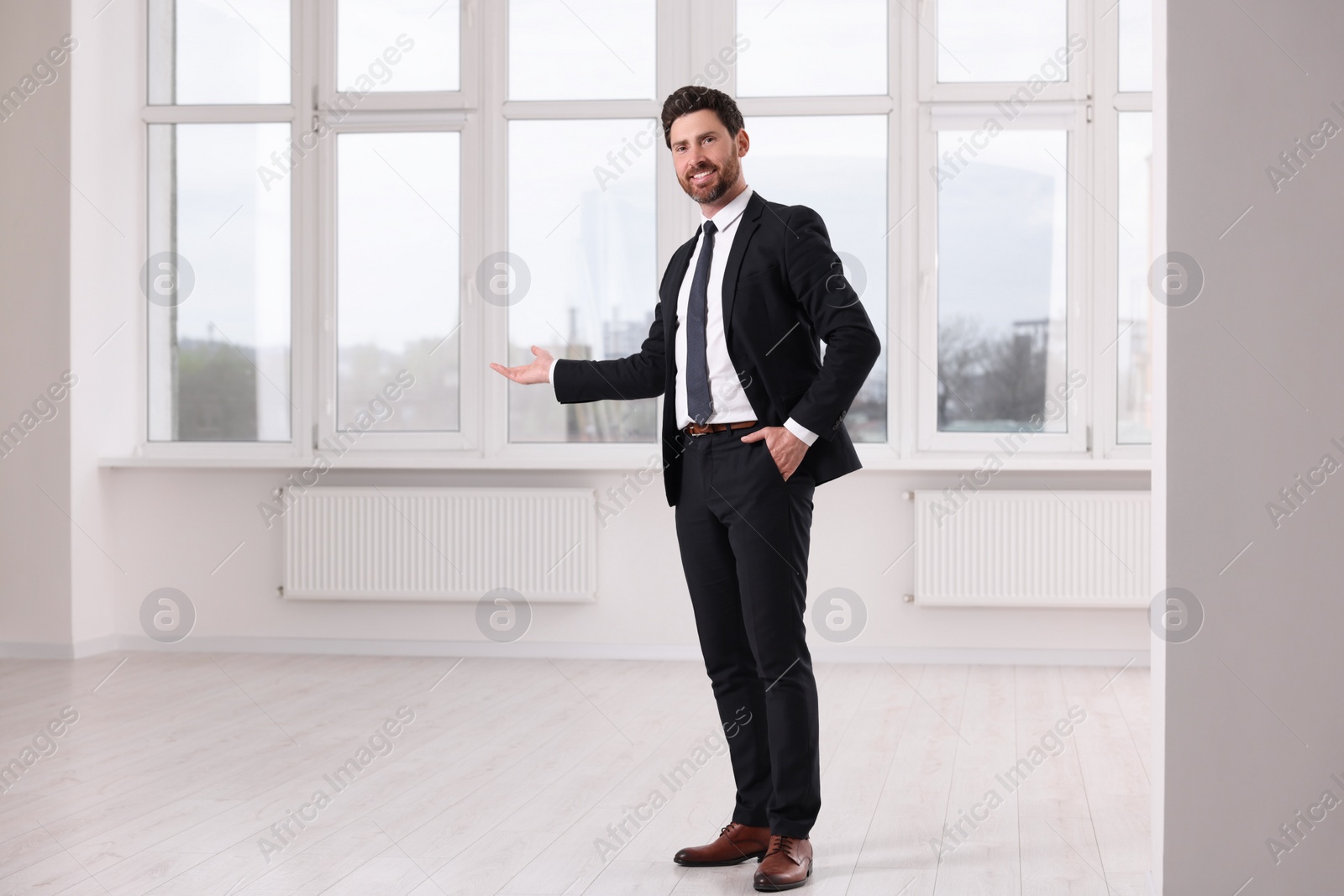 Photo of Happy real estate agent showing new apartment