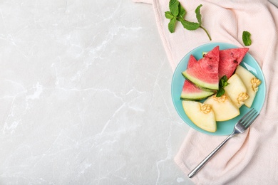 Photo of Flat lay composition with tasty sliced melon and watermelon on light background. Space for text