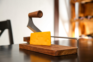 Slicer and piece of cheese on table