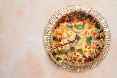 Photo of Delicious homemade quiche with salmon and broccoli on beige table, top view. Space for text