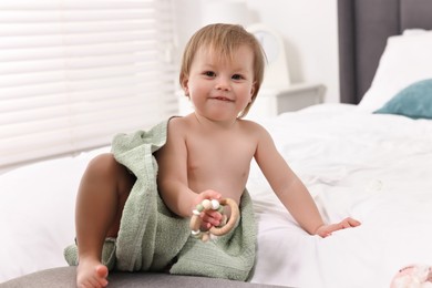 Photo of Cute little baby with towel after bathing on bed