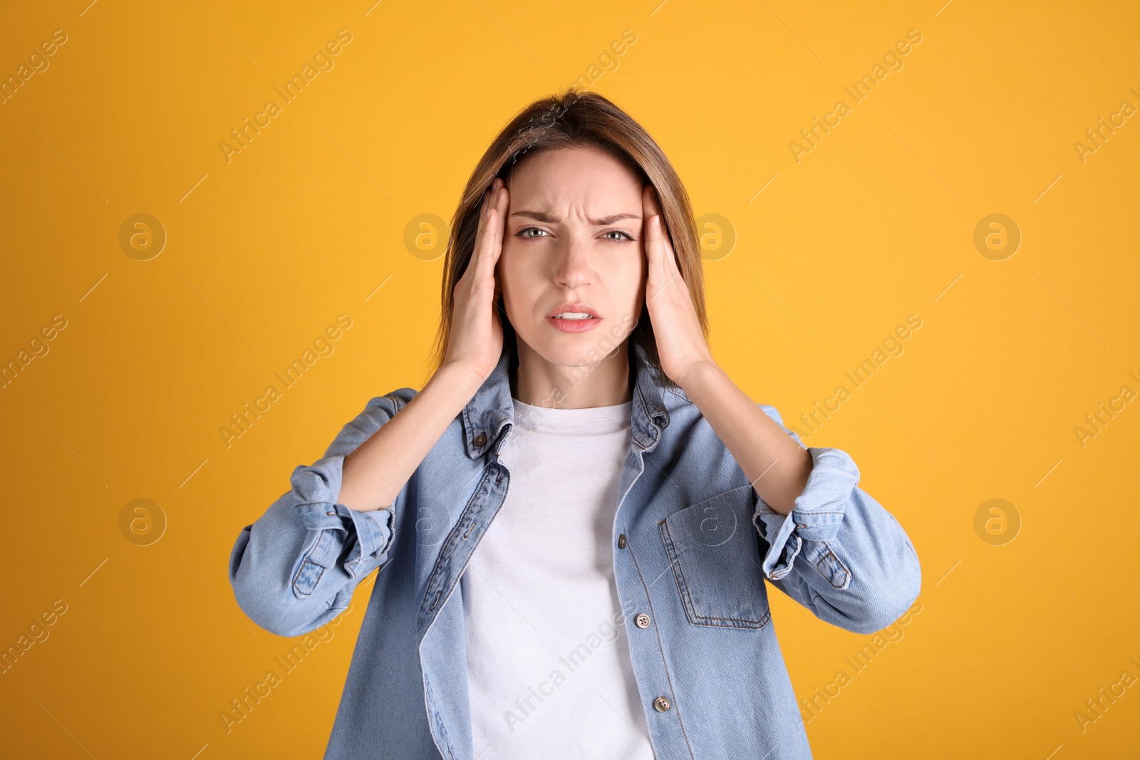 Photo of Portrait of stressed young woman on yellow background