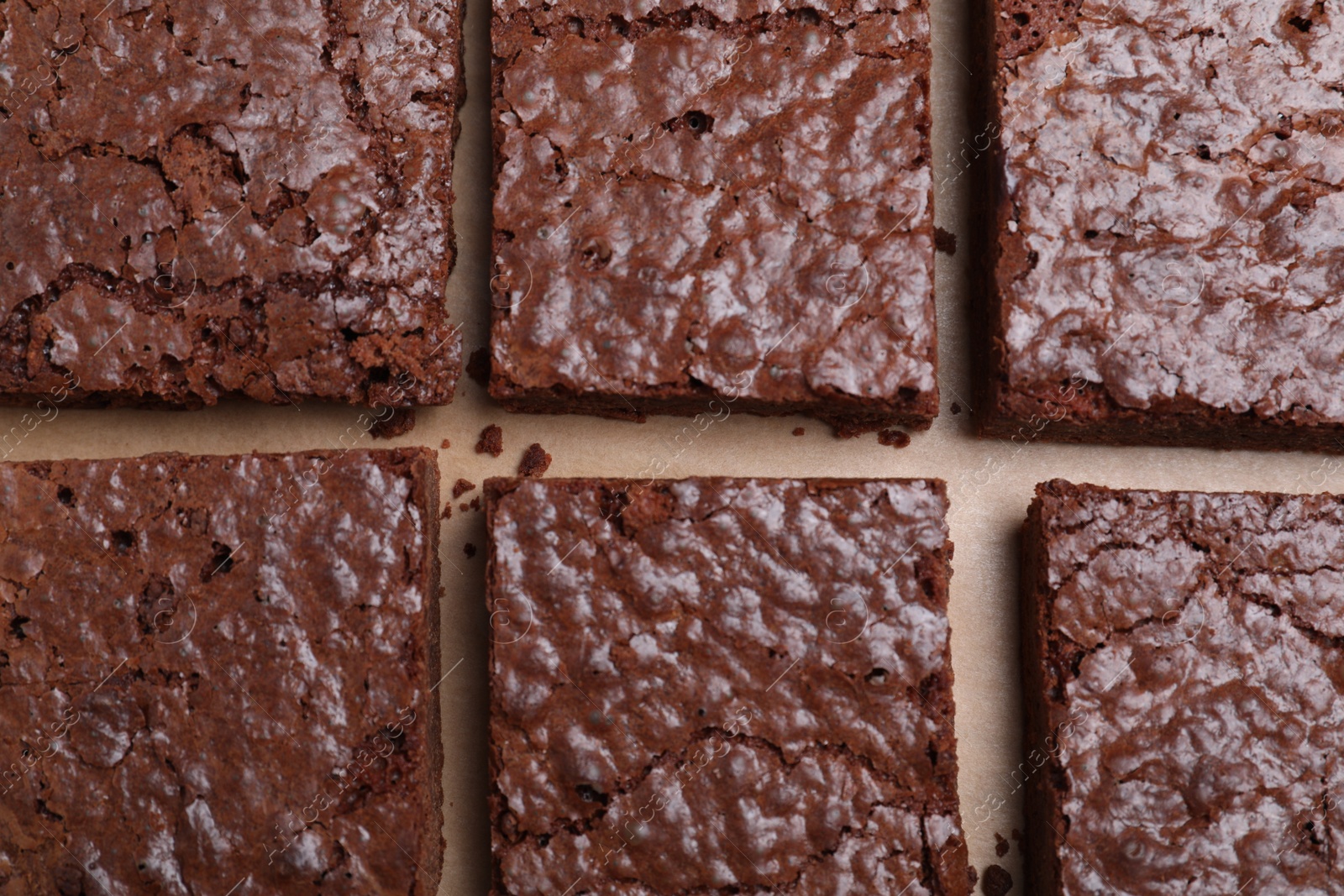 Photo of Delicious chocolate brownies on parchment paper, flat lay