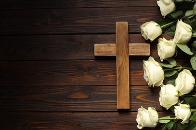 Photo of Cross and roses on wooden table, top view with space for text. Religion of Christianity