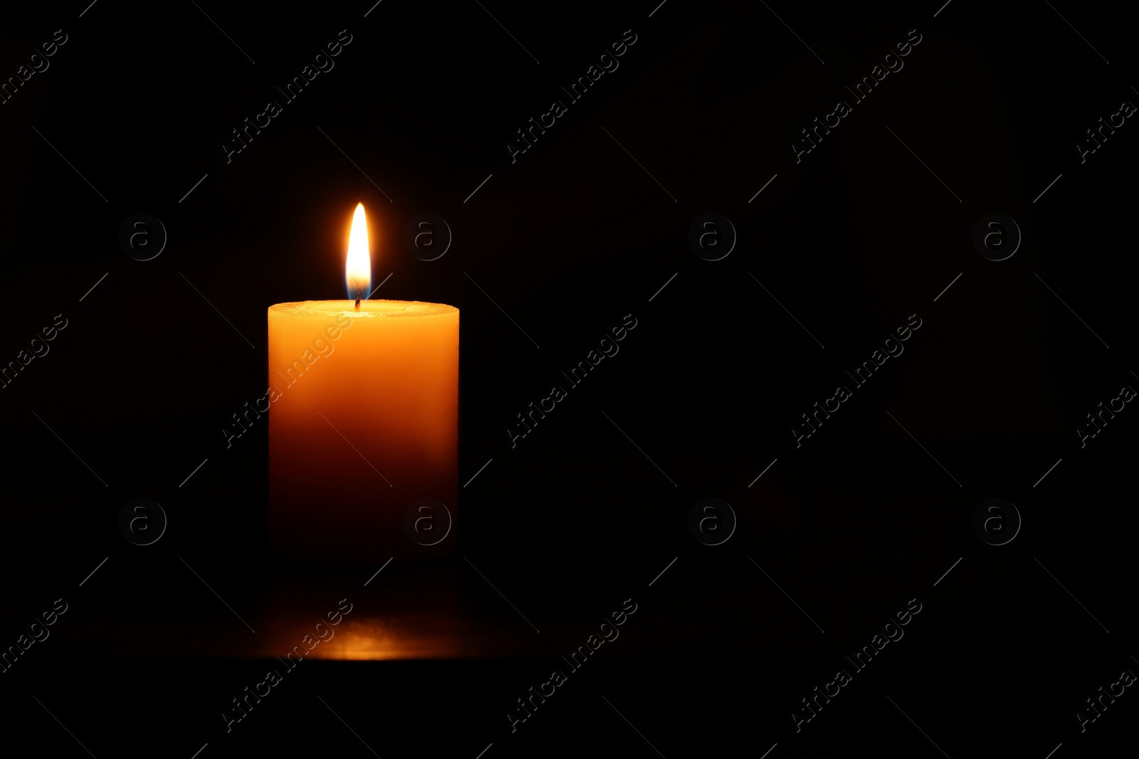 Photo of One burning candle on black background, space for text