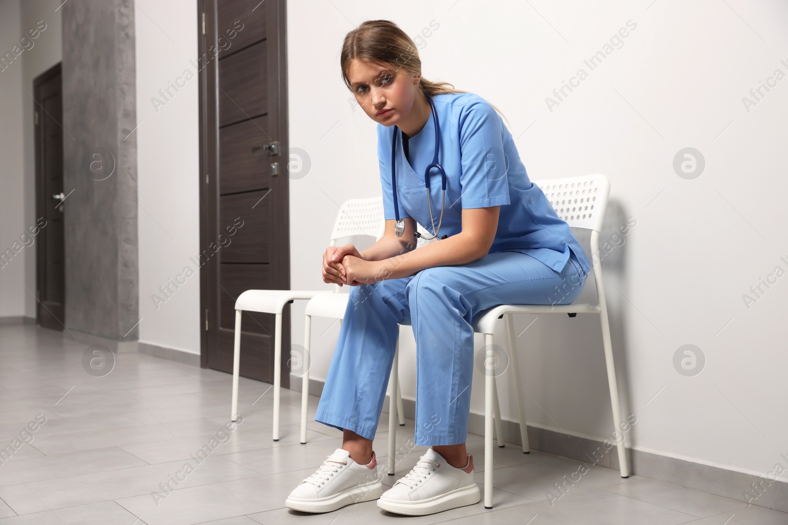 Photo of Exhausted doctor resting on chair in hospital