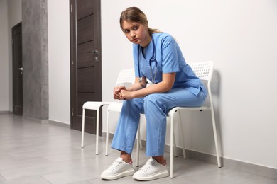 Exhausted doctor resting on chair in hospital